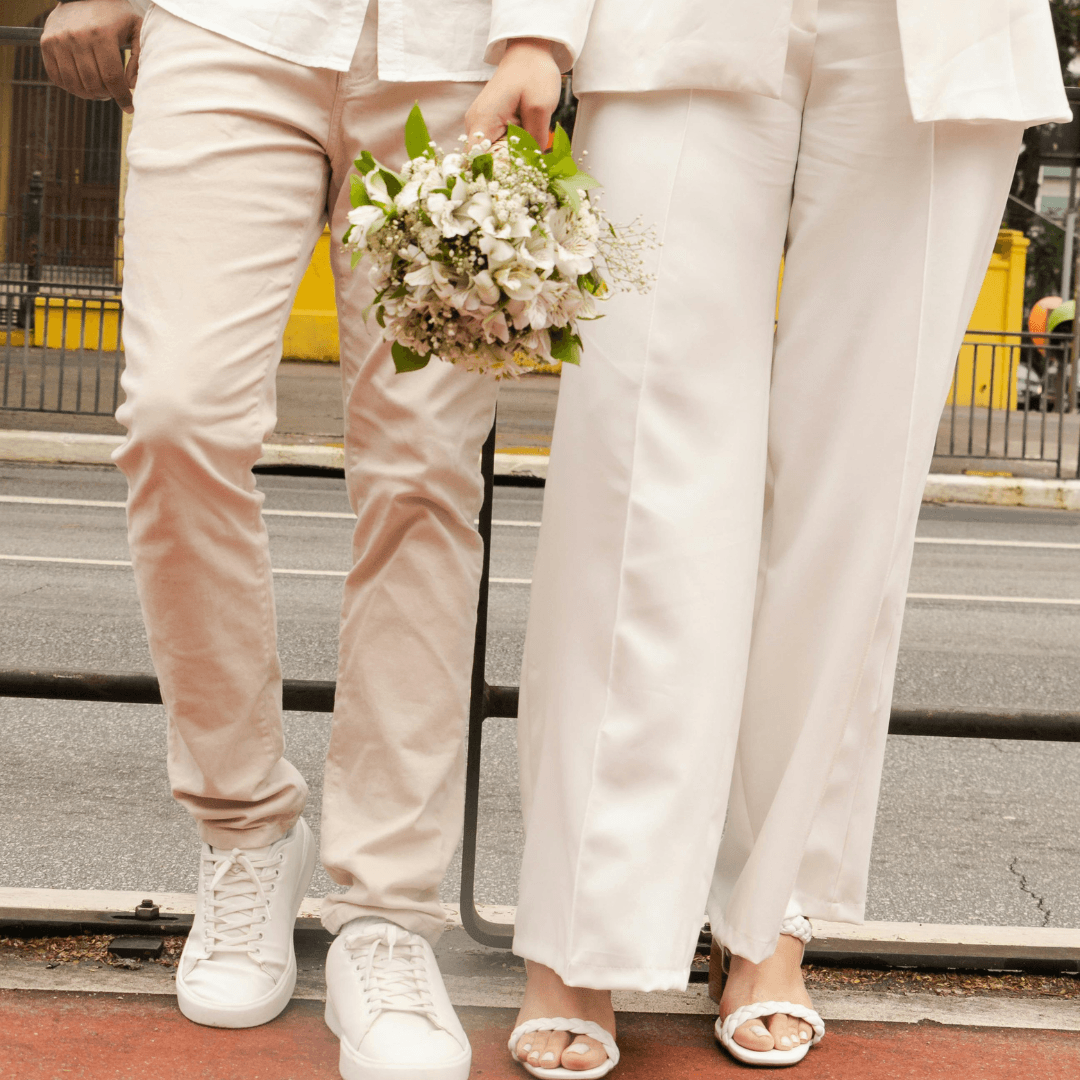 A stylish Filipino couple in a vintage-themed wedding. The groom is wearing a sharp, custom-fitted black tuxedo, and the bride is in a 1920s-inspired beaded gown with a finger-wave hairstyle